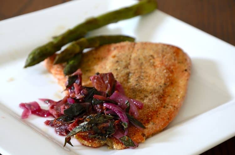 Panfried trout with cornmeal crust and blood orange relish on a plate