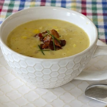 Bowl of thick, creamy corn chowder with bacon and chives