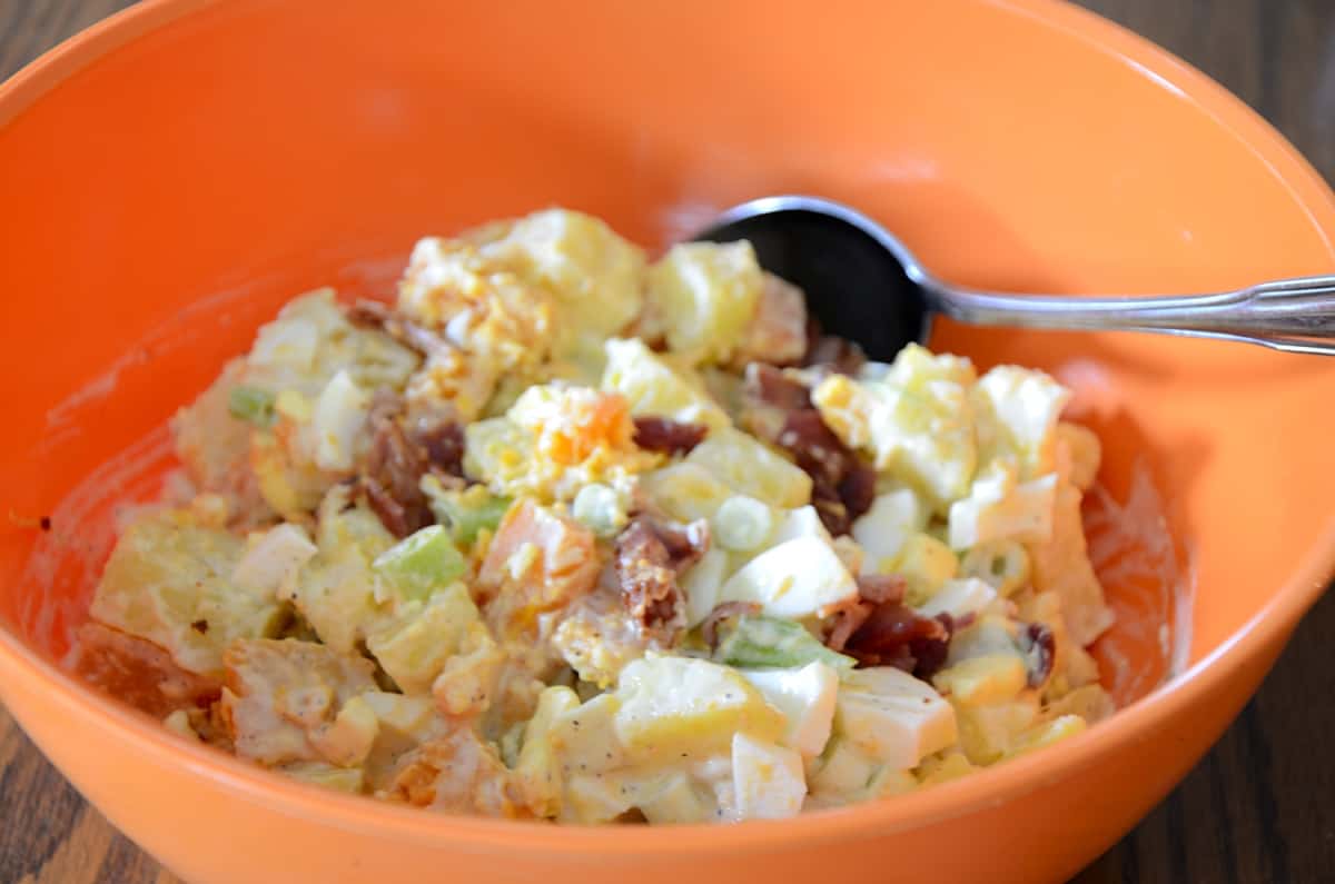 Potato salad with yellow and sweet potatoes, green onions and bacon bits in a creamy celery seed dressing.