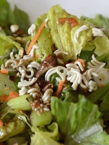Romaine lettuce with oriental dressing, toasted sesame seeds, almonds and green onions