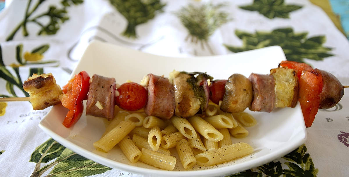 Panzanella Skewers on a bed of pasta with sausage,mushrooms, peppers, onion, basil and ciabatta bread cubes