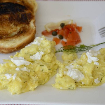 Softly scrambled eggs topped with goat cheese and fresh dill.