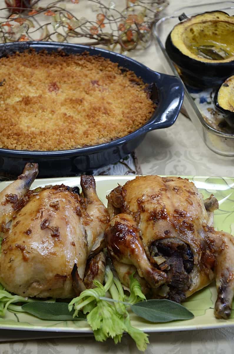 Table setting Cornish hens, stuffed with Root Vegetable casserole and baked squash.