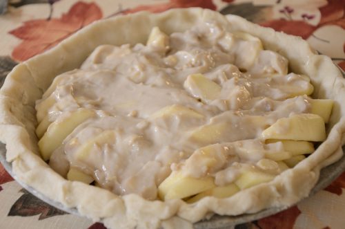 Pie shell with apple wedges and cream topping.