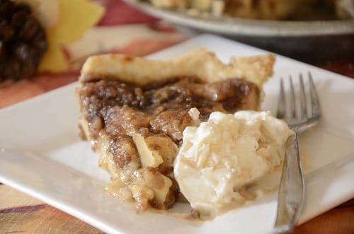 Slice of Schnitz pie on a plate with ice cream.