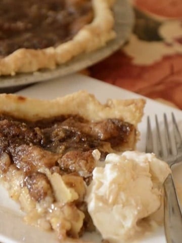 Slice of Schnitz pie on a plate with ice cream.