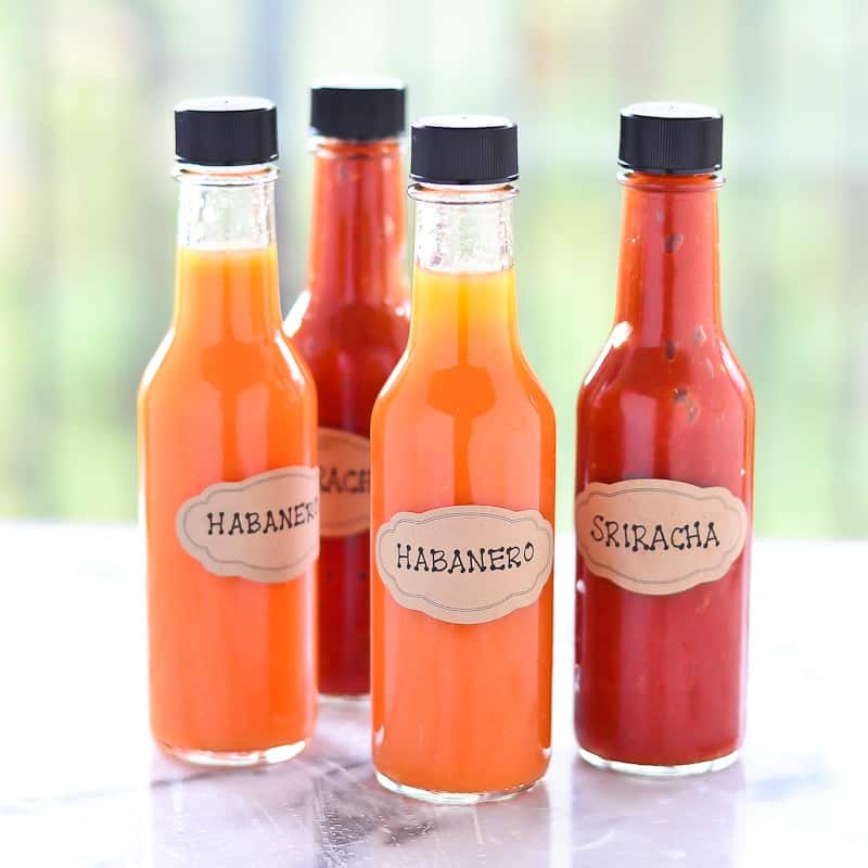 Small jars of habanero and siracha hot sauce.