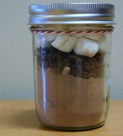 Mason jar of hot chocolate mix with marshmallows and chocolate chips.