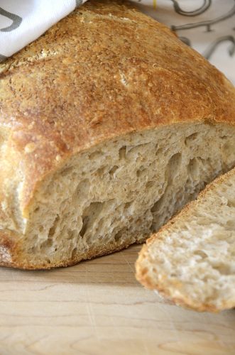 Loaf of Crispy sourdough bread cut on a cutting board.