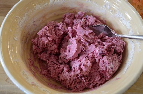 Pink coloured gnocchi dough in a bowl.