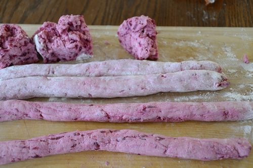 Beet gnocchi dough rolled into ropes.