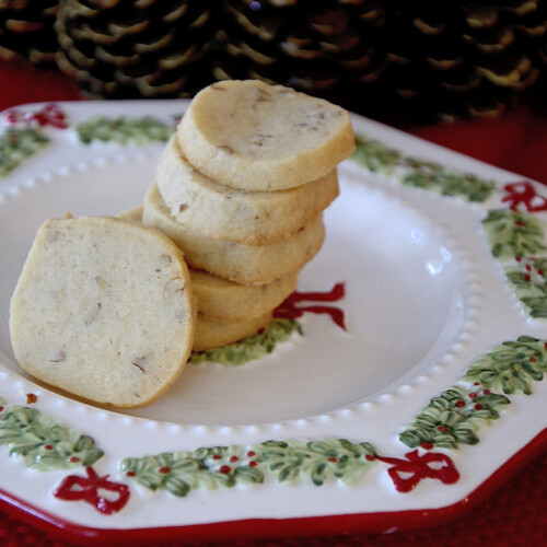 Stack of pecan shortbread cookies on a Christmas plate.