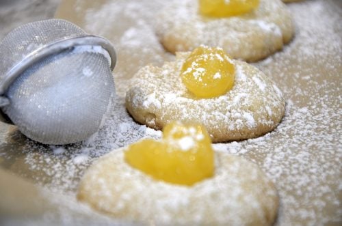 Thumbprint cookies with lemon curd filling on baking sheet.