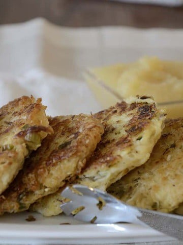 Fried sauerkraut cakes stacked on a serving plate.