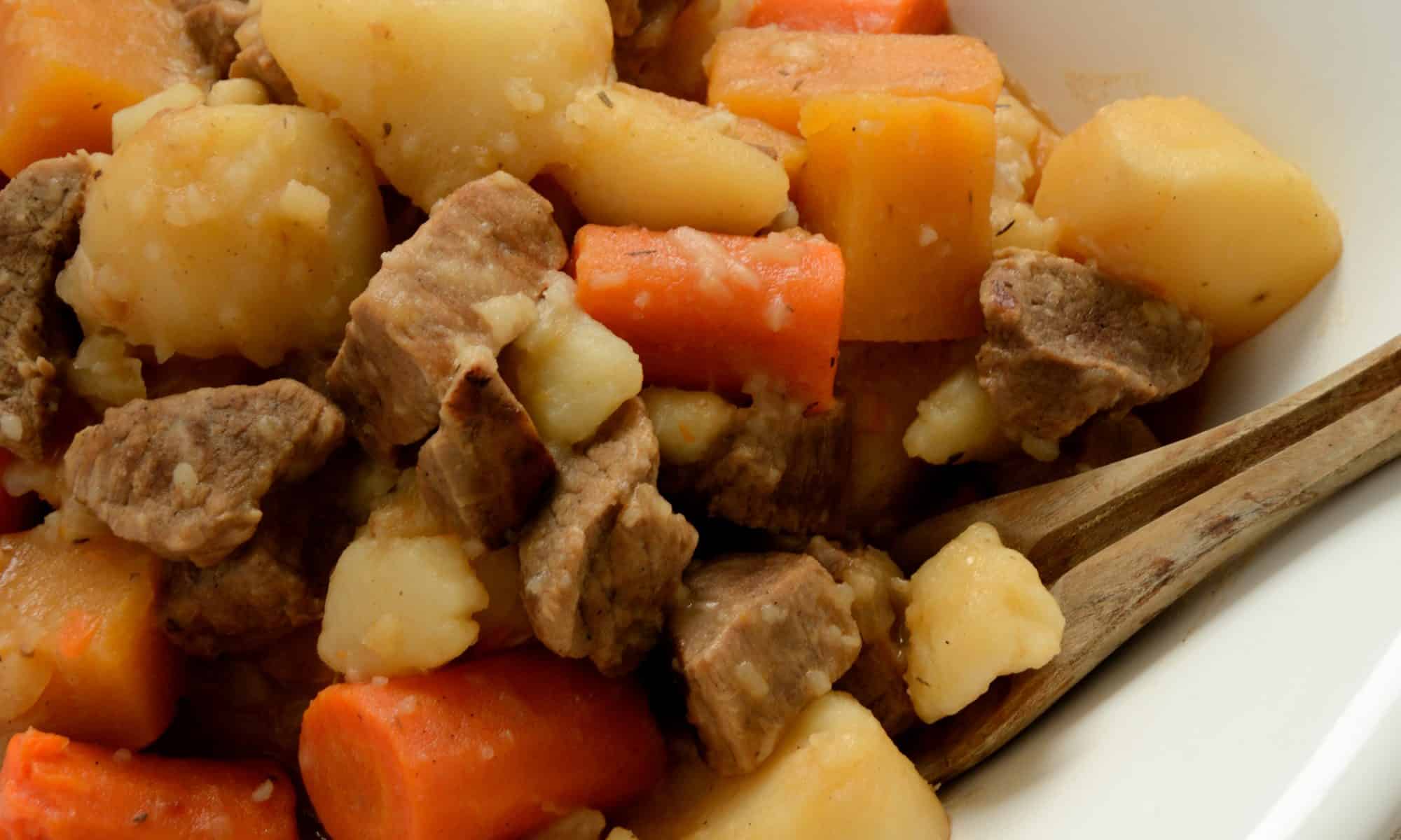 Close up of stewed beef cubes, carrots and potatoes.