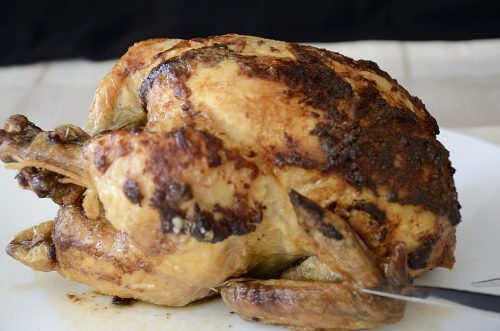 Golden brown rotisserie chicken with parmesan crust.
