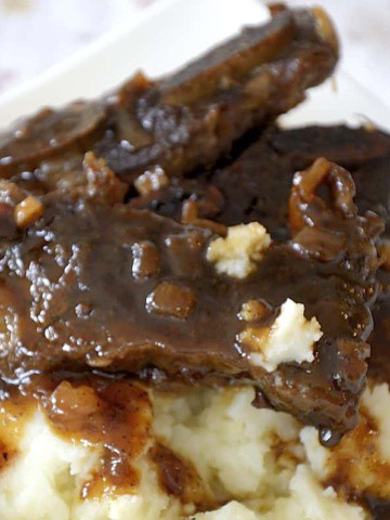 Beef short rib strips on a mound of mashed potatoes and glistening with sweet and sour glaze.