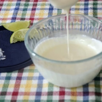 Bowl of creamy 'Crema Mexican' with some drizzling off a spoon.