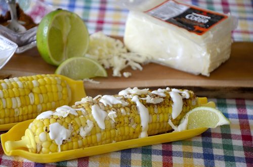 Corn on the cob garnished with mexican spices, grated cheese and mexican crema.