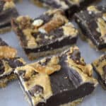 Chcolate squares on topped with salty pretzels and salted caramel.