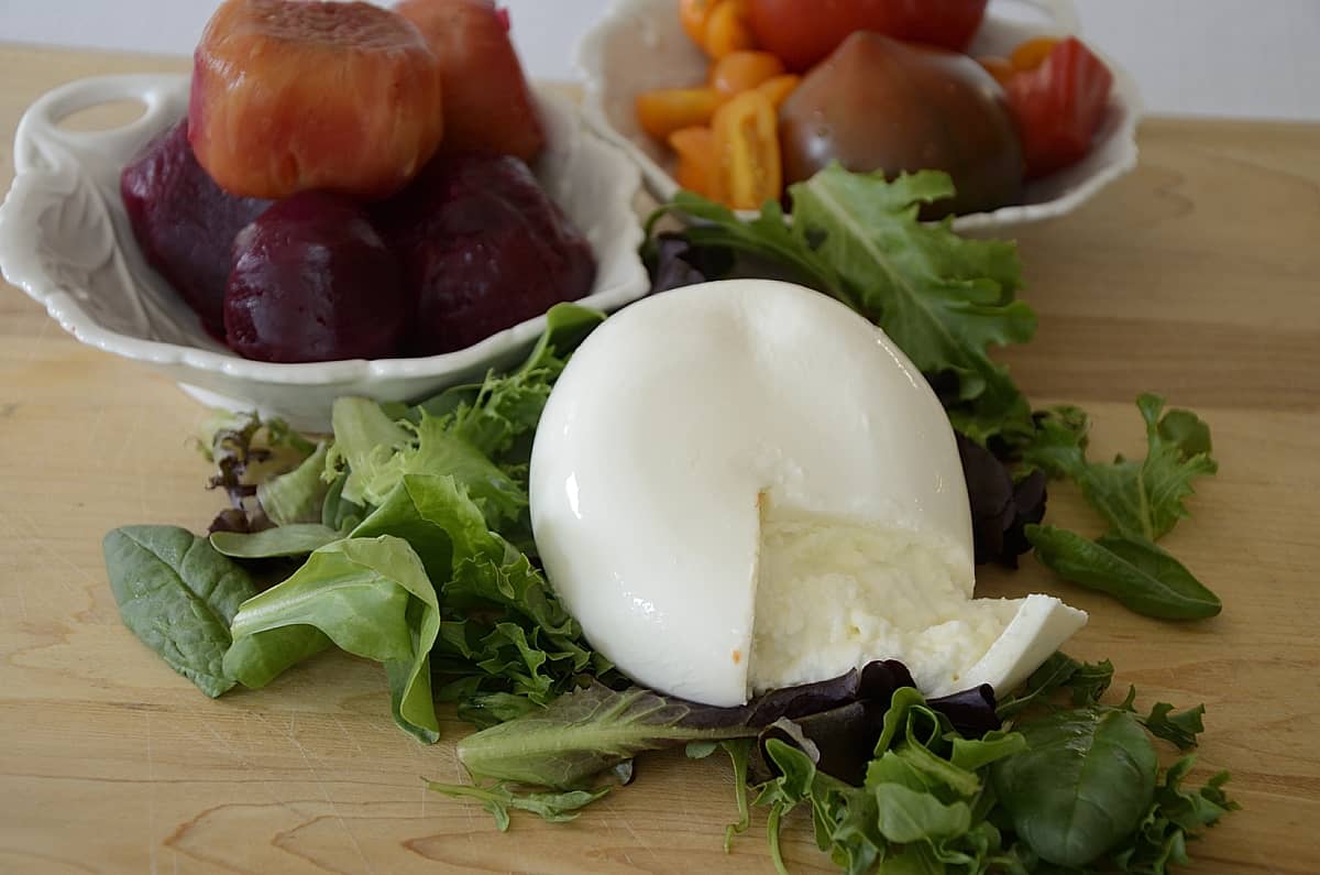 Wheel of Burrata Cheese with salad greens, beets and tomatoes.