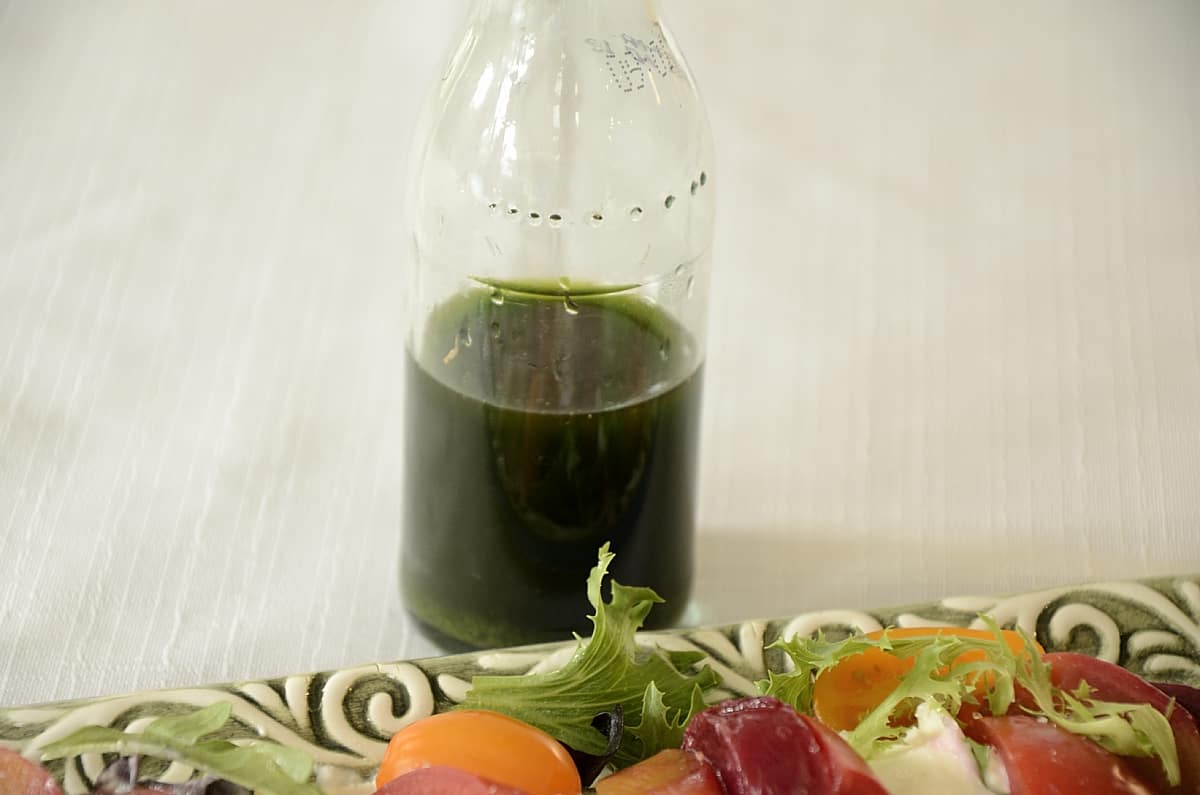 Small clear bottle of vibrant green basil oil.
