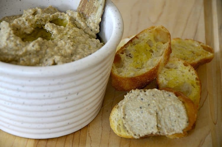 Roasted eggplant dip on crostini with bowl of dip off to the side.