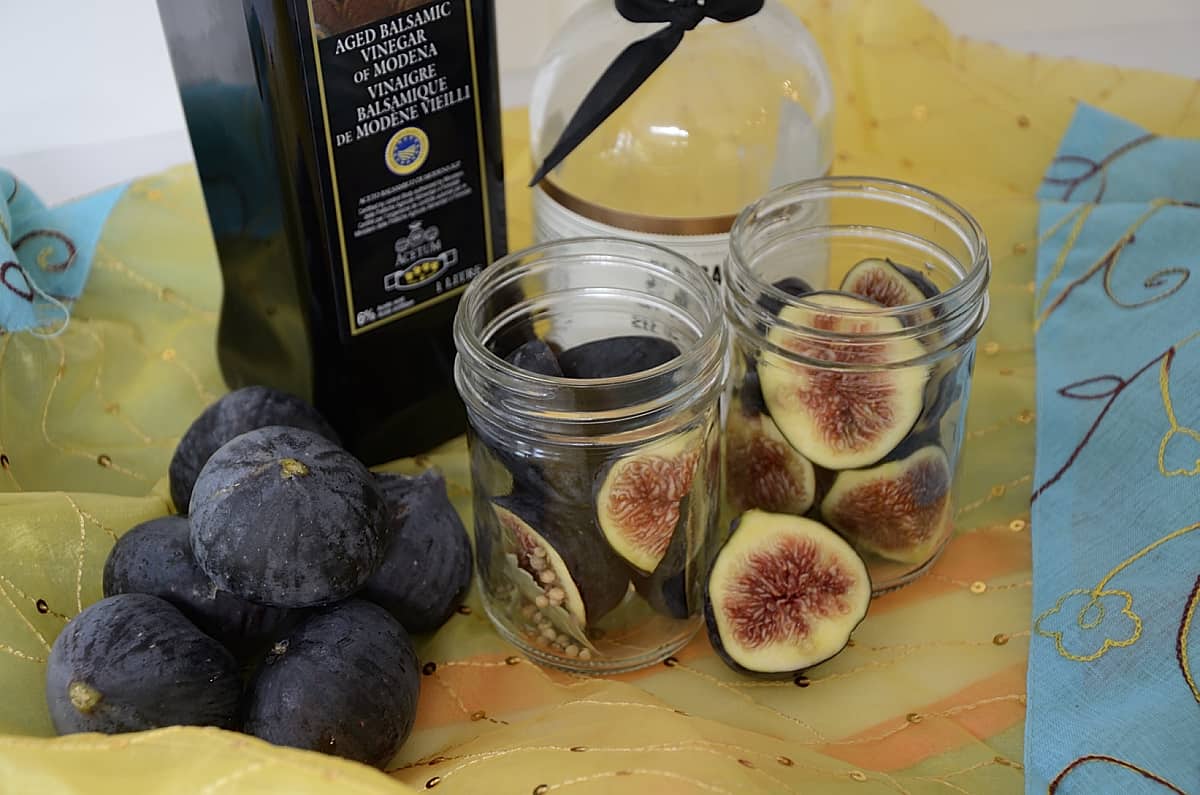 2 half pint jars of figs with balsamic vinegar and coarse sea salt beside them.