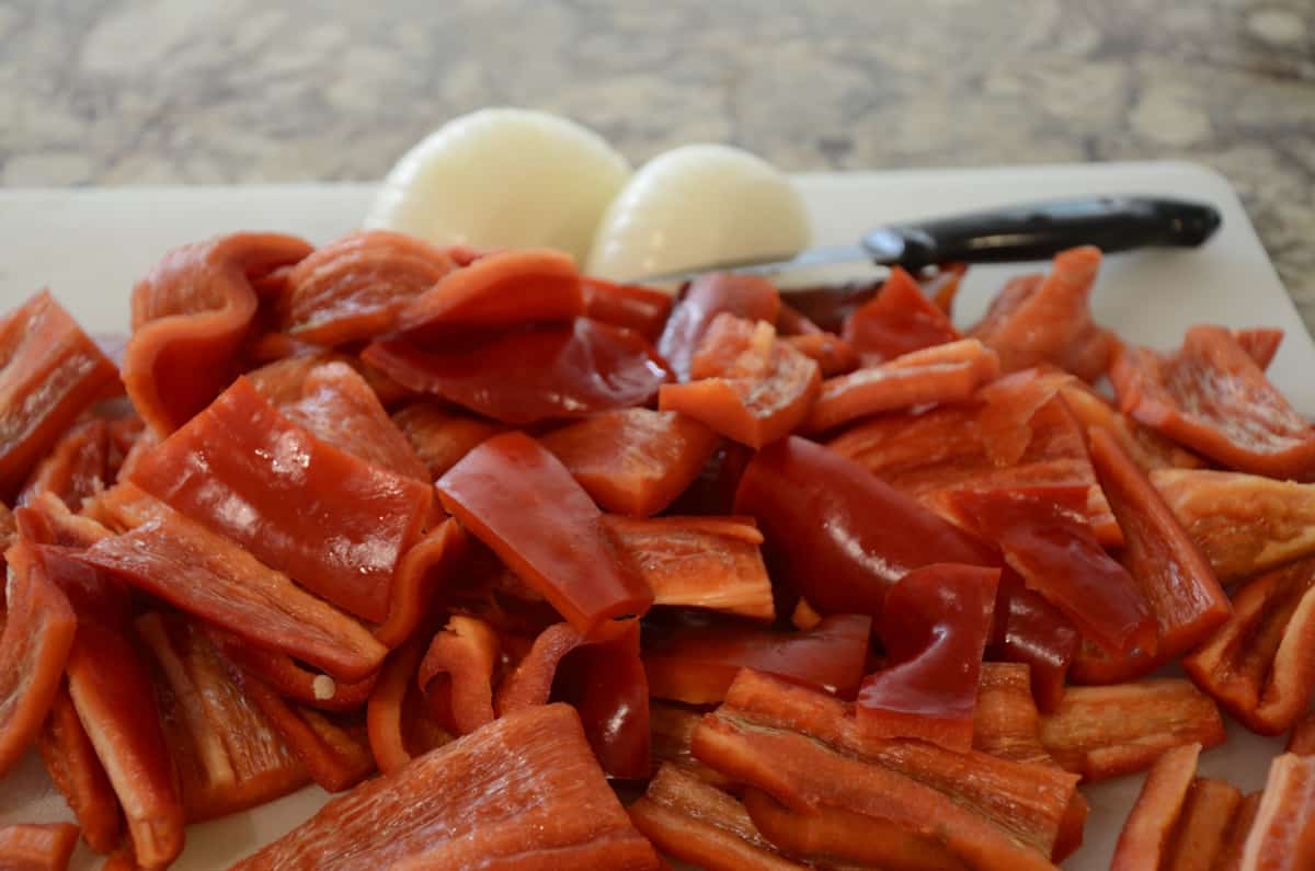 Red sweet pepper strips with onion slices ready for filling canning jars.