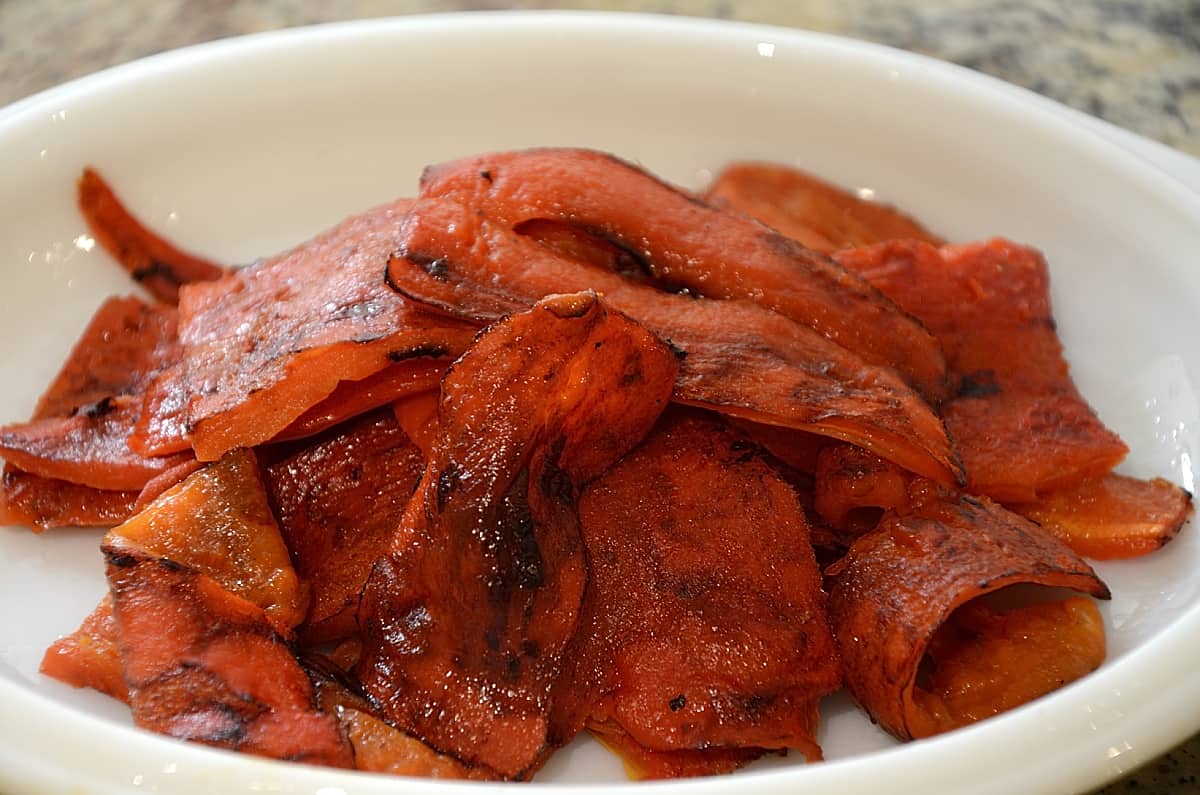 Peeled roasted red peppers on a plate.