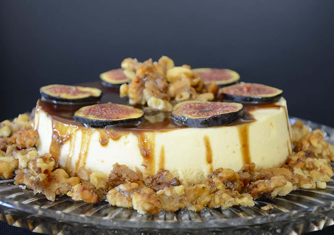 Creamy, cheesecake with balsamic caramel drizzled on top, garnished with fresh fig slices and candied walnuts.