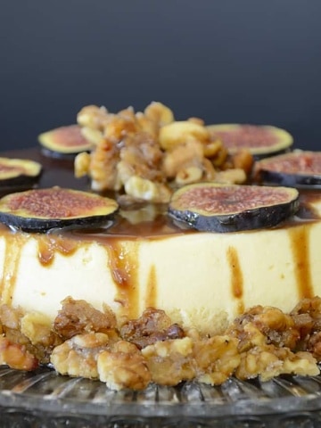 Creamy, cheesecake with balsamic caramel drizzled on top, garnished with fresh fig slices and candied walnuts.