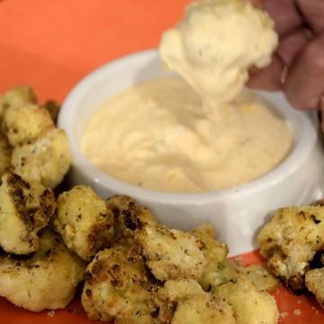Crispy air fried cauliflower wingon a platters with dipping sauce .