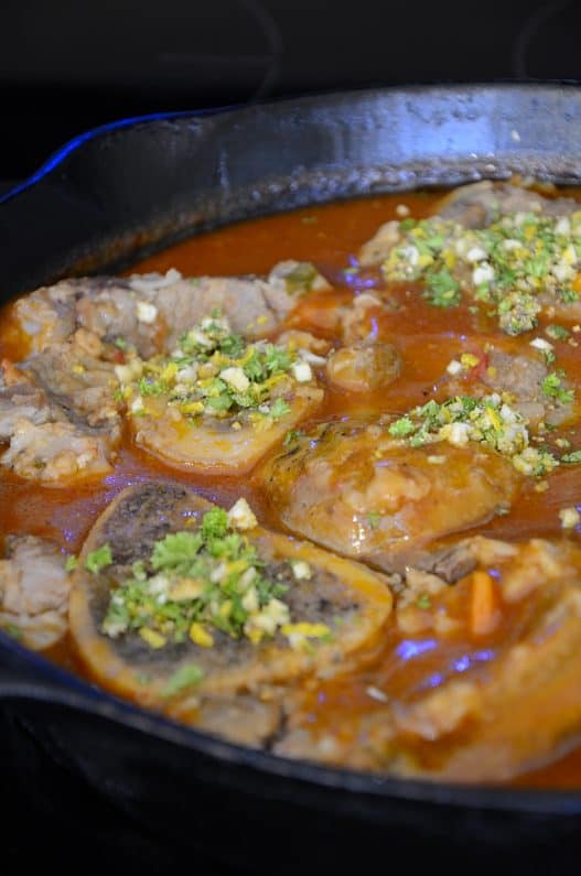 Skillet of braised veal shanks in tomato sauce with gremolata.