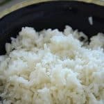 White rice in a black bowl .