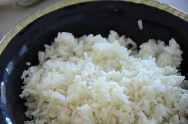 White rice in a black bowl that was cooked in the air fryer.