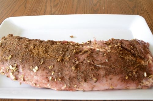 Slab of uncooked back ribs with dry rub.