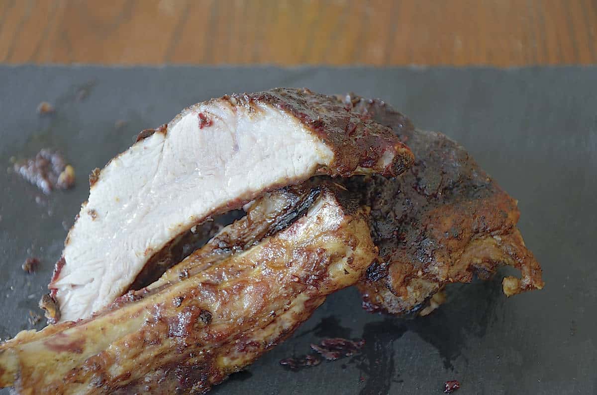 Air fried ribs with blackberry sauce cut open on a tray.