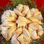 Baked Christmas Star bread on a bed of greenery.
