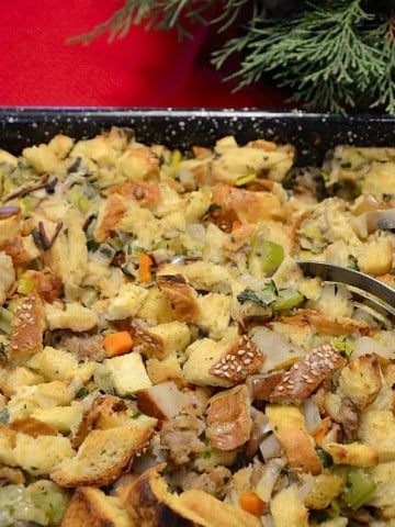 Brioche dressing in a roast pan with pears and honey garlic sausage.