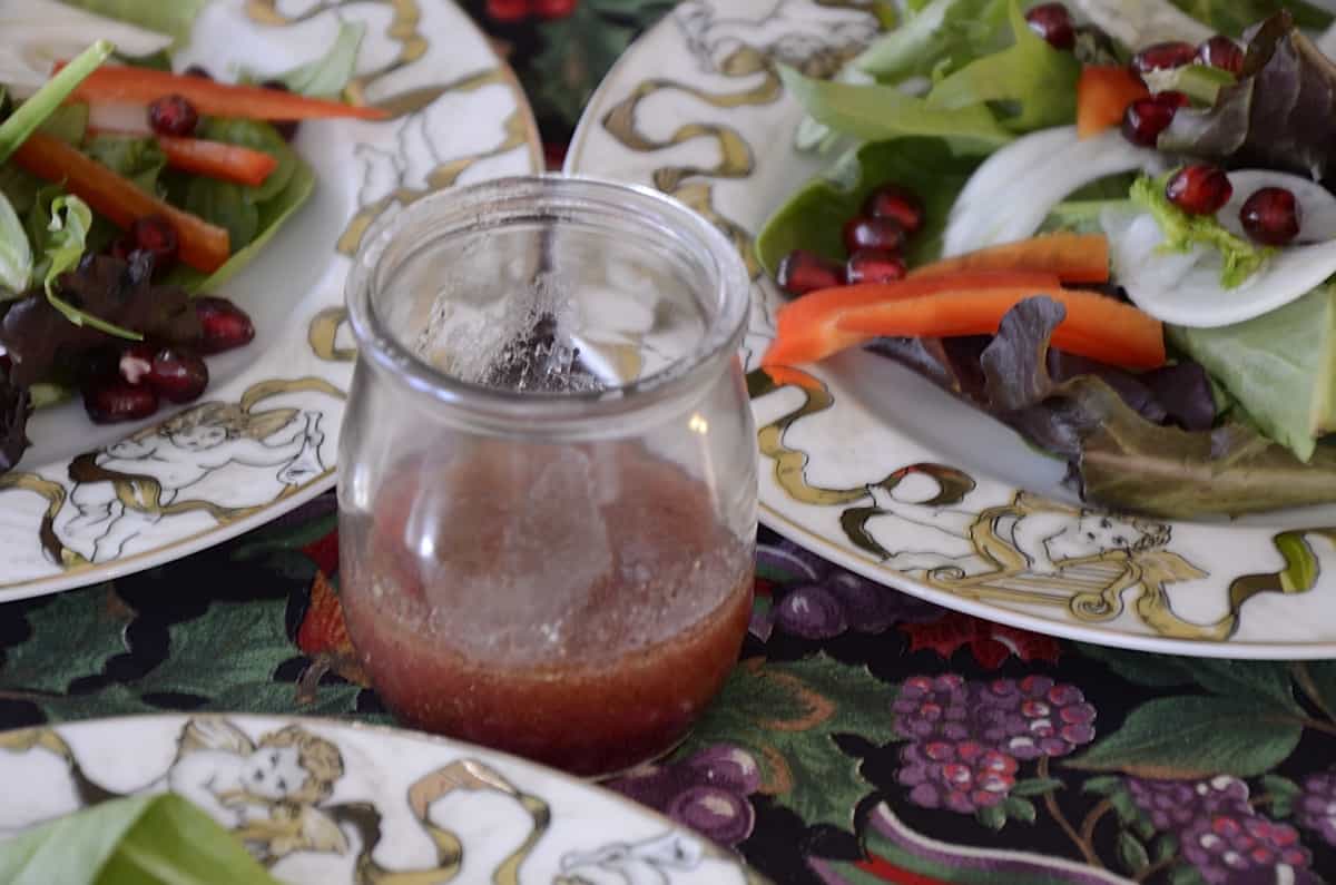 Pink prickly pear vinaigrette in a small glass beaker.