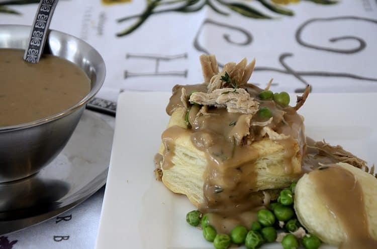 Leftover turkey bits in a puff pastry shell with Turkey Marsala Gracy drizzele over it and peas on the side.