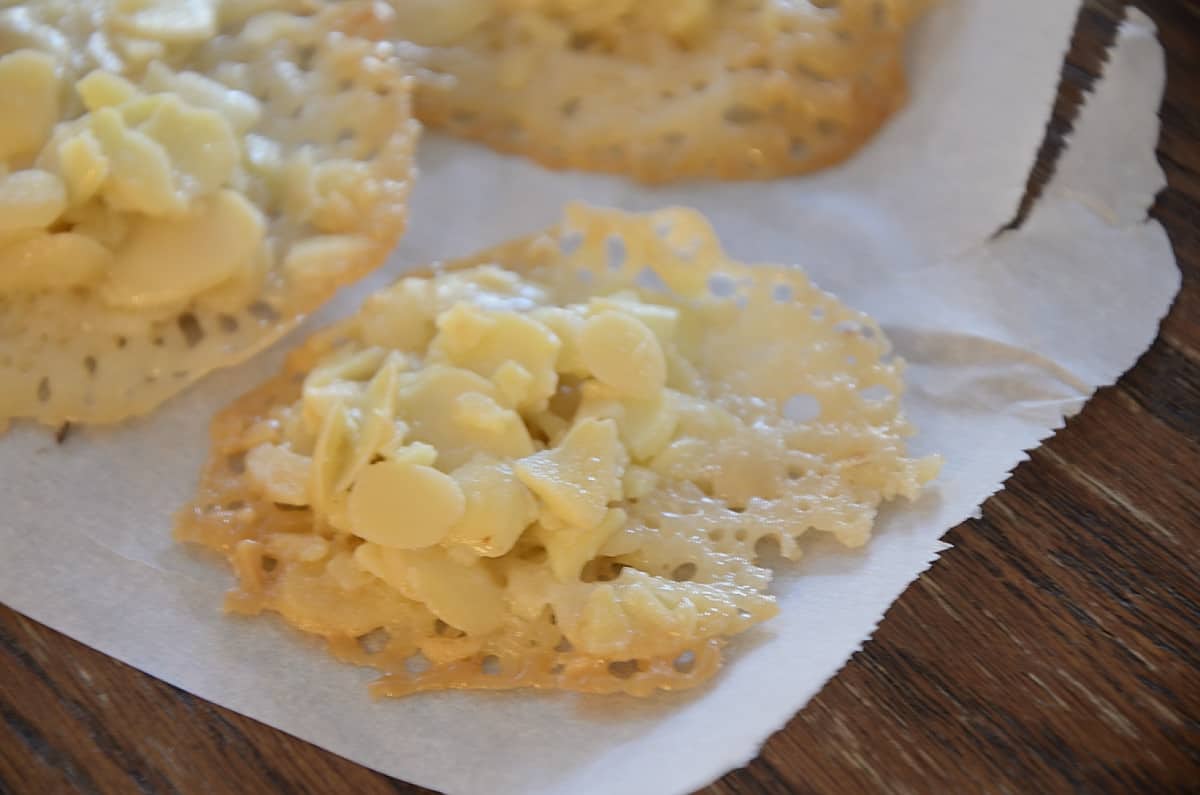 Lacy gluten free florentines on parchment paper.