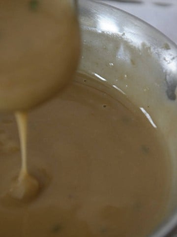 Turkey Marsala Gravy in a gravy ladle.