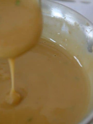 Creamy Turkey Marsala Gravy dripping off a gravy ladle.