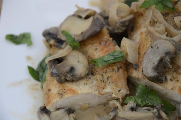 Browned chicken marsala cutlets in a mushroom cream sauce on a plate.