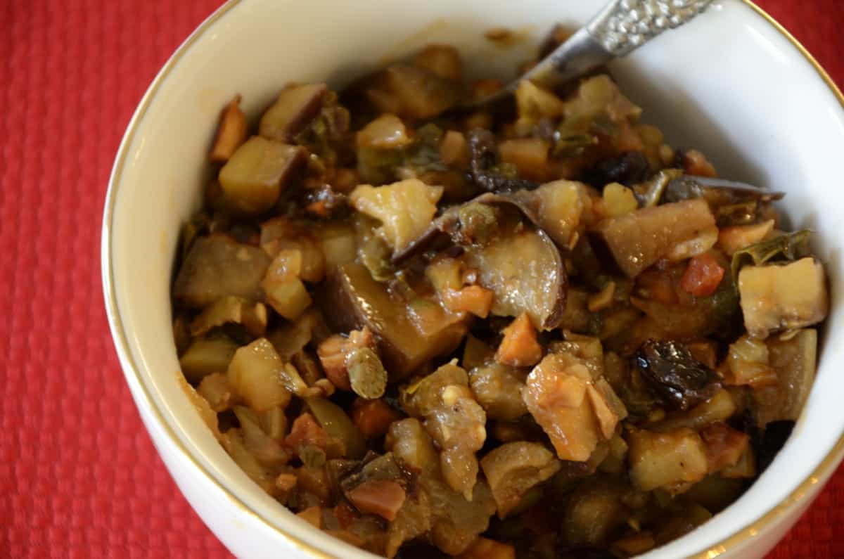 Close up of eggplant, olives, raisins and carrots in Sicilian Caponata mix.