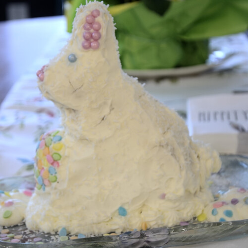 Easter bunny carrot cake decorated with cream cheese frosting and sprinkles.