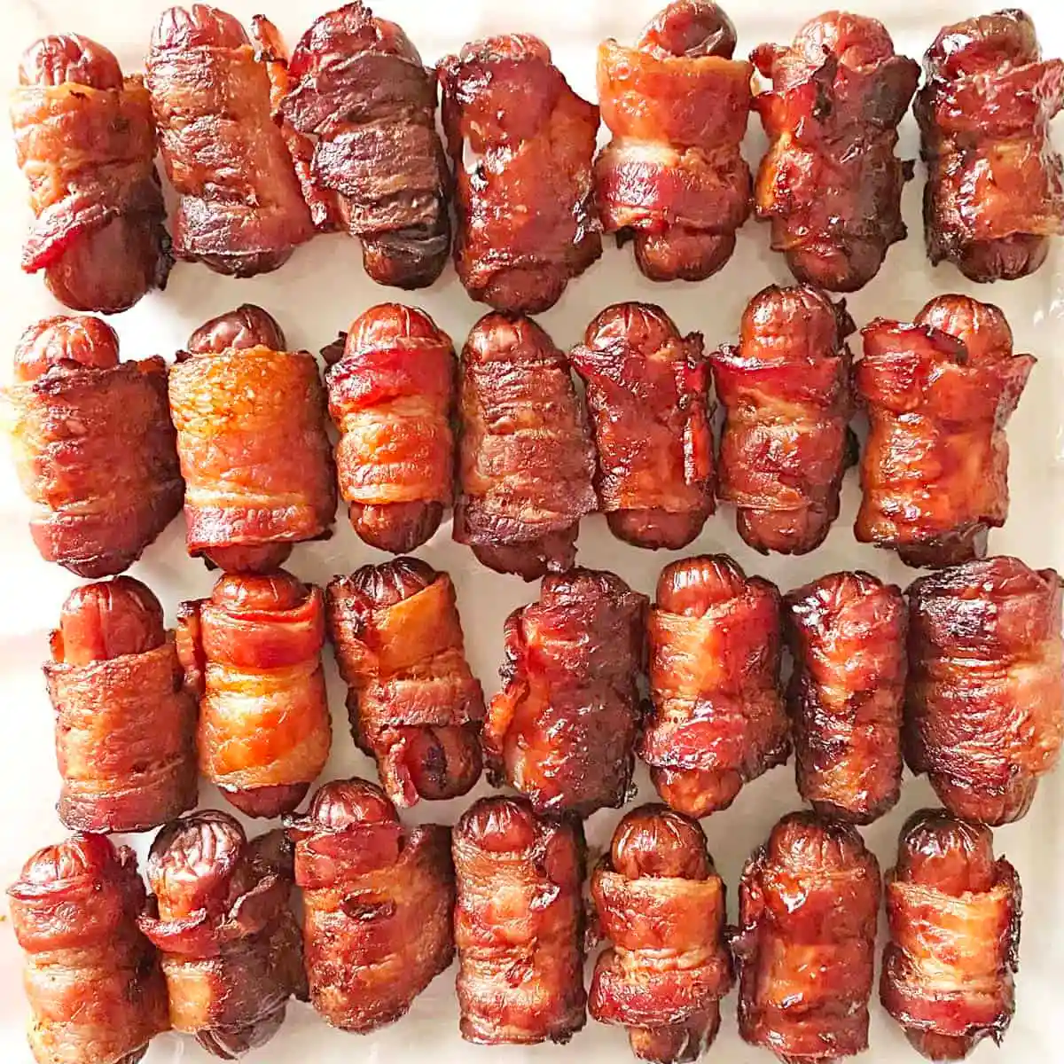 Little sausages wrapped in bacon crispy off the grill.