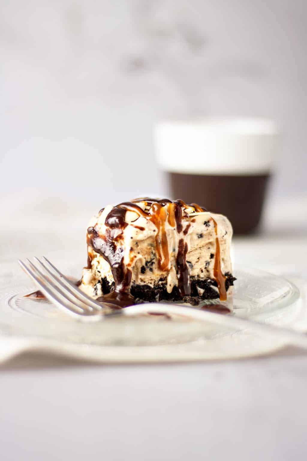 Close up of a half eaten piece of Billie Miner pie with oreo cookie base, cappucchino ice cream drizzled with chocolate fudge and caramel sauce.